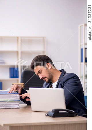 Young handsome employee working in the office Young handsome employee working in the office 84587281