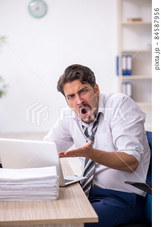 Young male employee working in the office Young male employee working in the office 84587956