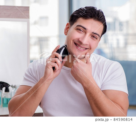 Young handsome man shaving in the morning Young handsome man shaving in the morning 84590814