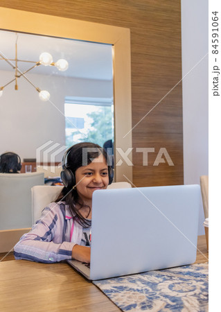 Teenage girl working with her laptop in her living room 84591064