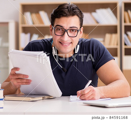Happy male student preparing for his exams Happy male student preparing for his exams 84591168