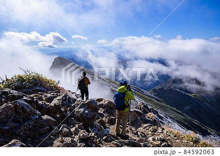 雪化粧した谷川岳山頂から景色を眺める人 84592063