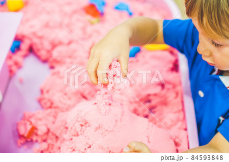 Boy playing with kinetic sand in preschool. The development of fine motor concept. Creativity Game concept 84593848