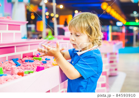 Boy playing with kinetic sand in preschool. The development of fine motor concept. Creativity Game concept Boy playing with kinetic sand in preschool. The development of fine motor concept. Creativity Game concept 84593910