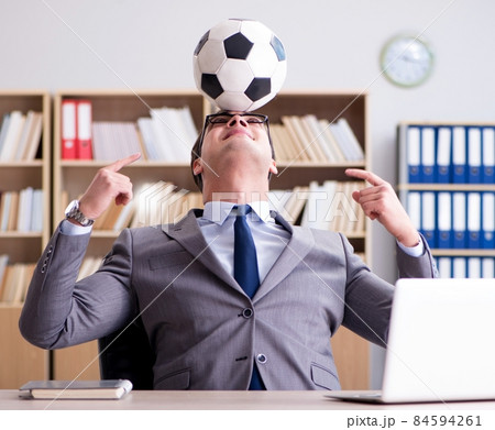 Businessman with football ball in office Businessman with football ball in office 84594261