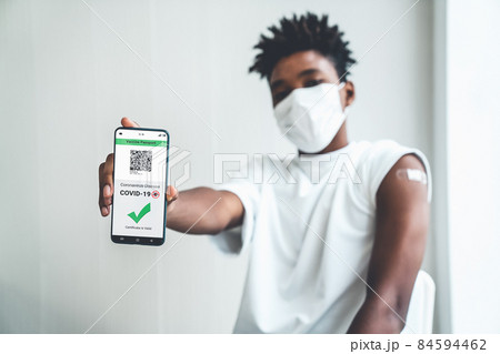 African American teenager shows vaccine passport on mobile phone 84594462