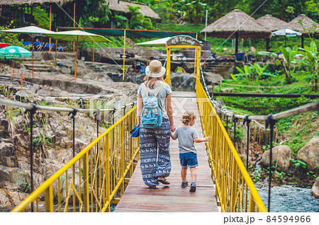 Mother and son are going on a suspension bridge. Traveling with children concept 84594966