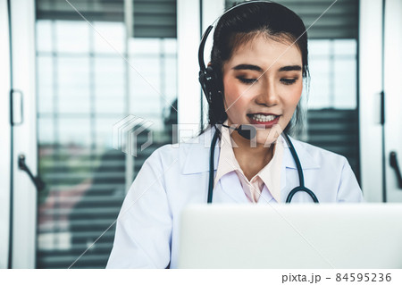 Doctor wearing headset talking actively on video call in hospital or clinic 84595236