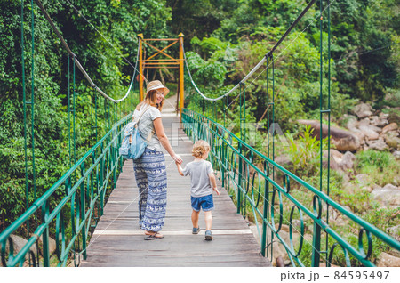 Mother and son are going on a suspension bridge. Traveling with children concept 84595497