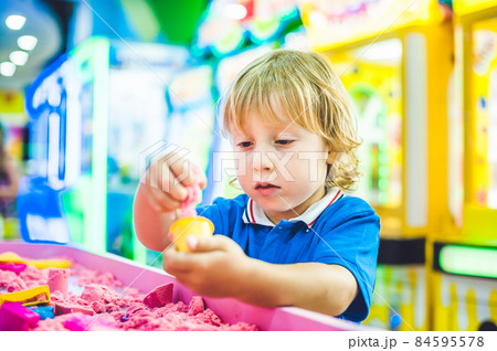 Boy playing with kinetic sand in preschool. The development of fine motor concept. Creativity Game concept 84595578
