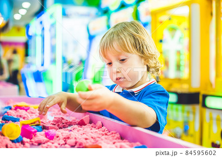Boy playing with kinetic sand in preschool. The development of fine motor concept. Creativity Game concept Boy playing with kinetic sand in preschool. The development of fine motor concept. Creativity Game concept 84595602