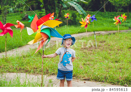 Cute little boy and a pinwheel windmill Cute little boy and a pinwheel windmill 84595613