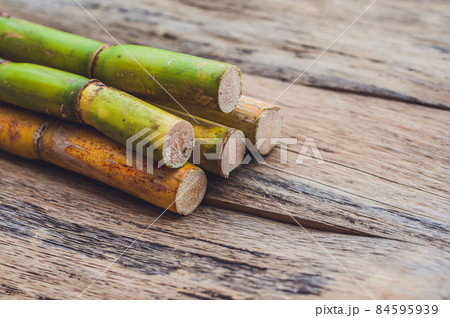 Stalks of sugar cane on the old wooden background Stalks of sugar cane on the old wooden background 84595939