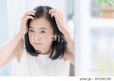 鏡を見ながら髪のチェックをするミドルエイジの女性 84596196