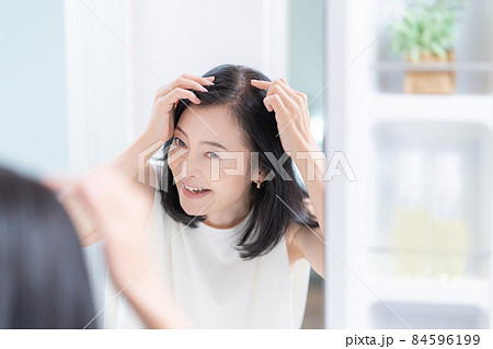 鏡を見ながら髪のチェックをするミドルエイジの女性 84596199