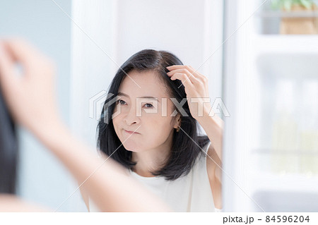 鏡を見ながら髪のチェックをするミドルエイジの女性 84596204