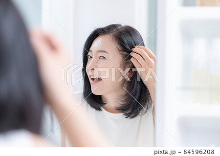 鏡を見ながら髪のチェックをするミドルエイジの女性 84596208