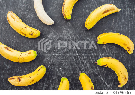 Banana cocktail and fresh bananas on the old wooden background 84596565