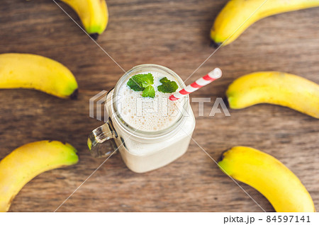 Banana cocktail and fresh bananas on the old wooden background Banana cocktail and fresh bananas on the old wooden background 84597141