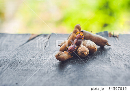 Sweet ripe tamarind pods on old wood background 84597816