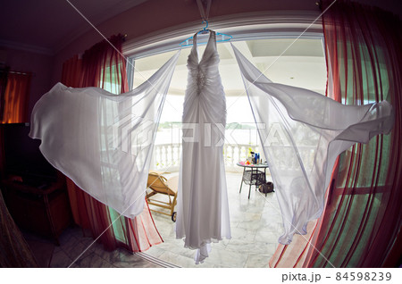 Wedding dress at the hotel on the background of the pool, ocean and mountains 84598239