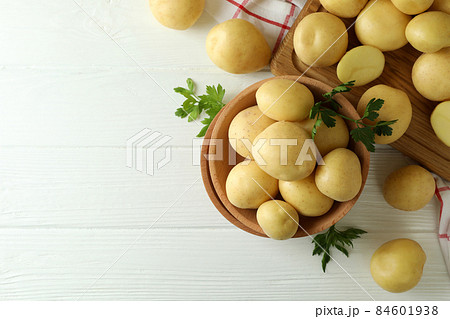 Wooden bowl with young potato on white wooden table Wooden bowl with young potato on white wooden table 84601938