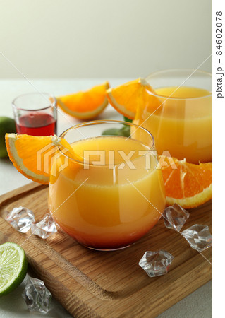Board with Tequila Sunrise cocktails on white textured table Board with Tequila Sunrise cocktails on white textured table 84602078