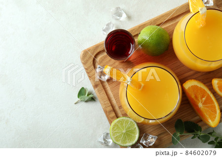 Board with Tequila Sunrise cocktails on white textured table Board with Tequila Sunrise cocktails on white textured table 84602079