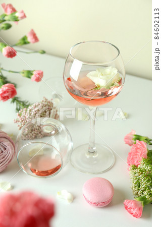 Wine, sweet food and flowers on white table Wine, sweet food and flowers on white table 84602113