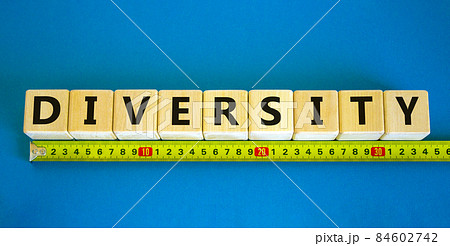 Diversity and better inclusion symbol. The concept word Diversity on wooden cubes. Yellow ruler. Beautiful blue table, blue background. Business, inclusion and diversity concept, copy space. 84602742