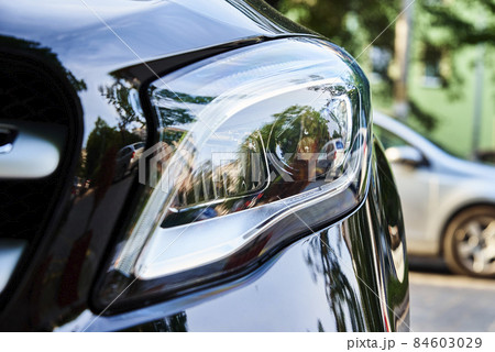 Headlight with halogen lamp on modern car, closeup Headlight with halogen lamp on modern car, closeup 84603029