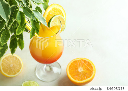 Tequila sunrise cocktail and ingredients on white textured table Tequila sunrise cocktail and ingredients on white textured table 84603353