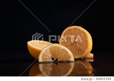Slices of lemon citrus on the table juicy cut off reflection in the water juice blurred background 84603394