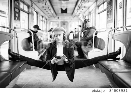 Very flexible woman wearing mask reading book in the subway car sitting in the gymnastic split. Concept of healthy lifestyle and education Very flexible woman wearing mask reading book in the subway car sitting in the gymnastic split. Concept of healthy lifestyle and education 84603981