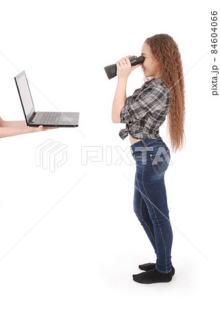 Happy teen school girl using binoculars looking at laptop screen 84604066