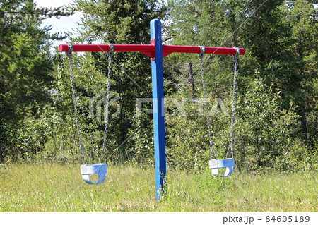 A view of baby swings in a playground 84605189
