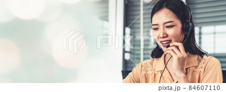Businesswoman wearing headset working actively in office Businesswoman wearing headset working actively in office 84607110