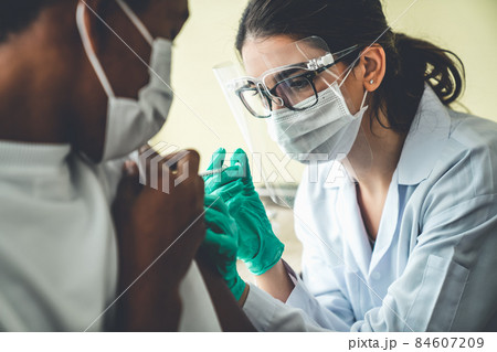 Young man visits skillful doctor at hospital for vaccination Young man visits skillful doctor at hospital for vaccination 84607209
