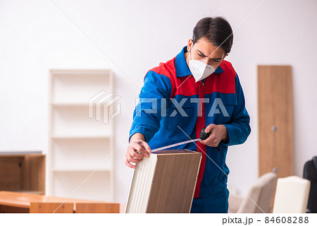 Young male carpenter working in the office during pandemic 84608288