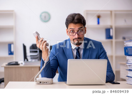 Young businessman employee unhappy with excessive work in the of Young businessman employee unhappy with excessive work in the of 84609439