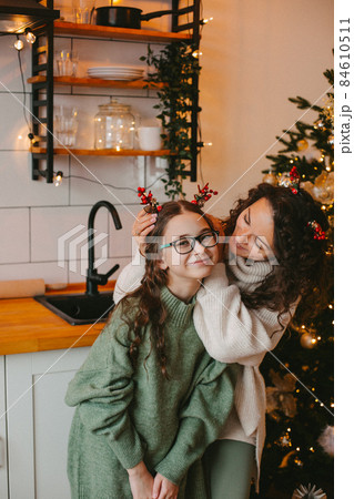 Happy young woman with cute teenage daughter in christmas interior Happy young woman with cute teenage daughter in christmas interior 84610511