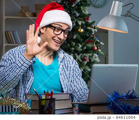 Young man working at home on christmas day Young man working at home on christmas day 84611004