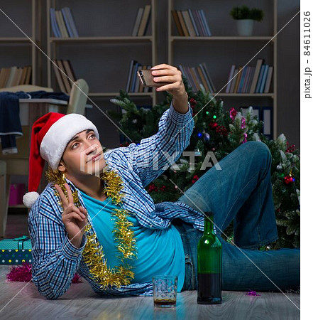 Man celebrating christmas at home alone 84611026