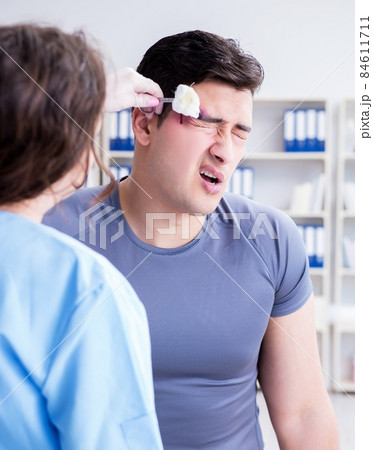 Young man visiting female traumatologist with black eye 84611711