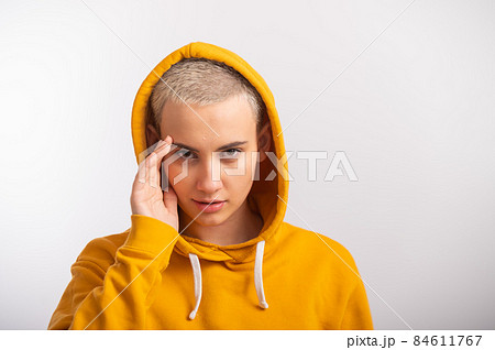 Young woman in an ocher hood on a white background. Young woman in an ocher hood on a white background. 84611767
