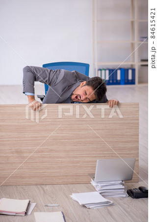 Young male employee working overtime in the office Young male employee working overtime in the office 84615421