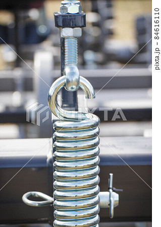 Hard silver spring made of steel. Part and detail of industrial or agricultural machine Hard silver spring made of steel. Part and detail of industrial or agricultural machine 84616110