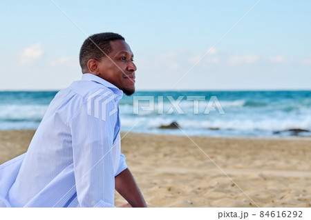 Young positive man looking in profile on the beach, copy space Young positive man looking in profile on the beach, copy space 84616292