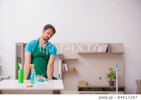 Young male contractor cleaning the house Young male contractor cleaning the house 84617207