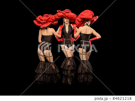 Three beautiful cabaret dancers in red hats isolated on black 84621218
